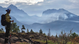 A firefighter observes a distant fire in Jasper National Park.